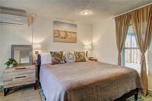 bedroom with a wall unit AC and a textured ceiling