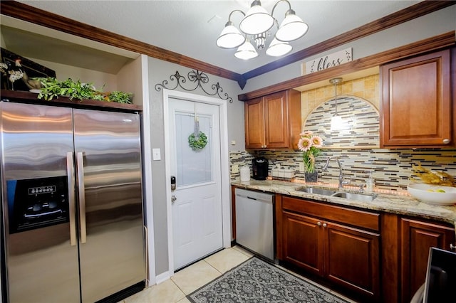 kitchen featuring sink, an inviting chandelier, crown molding, pendant lighting, and appliances with stainless steel finishes