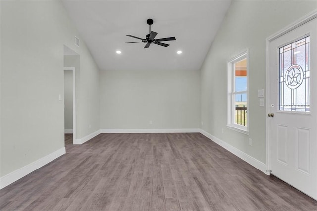 entrance foyer with vaulted ceiling, wood finished floors, visible vents, and baseboards