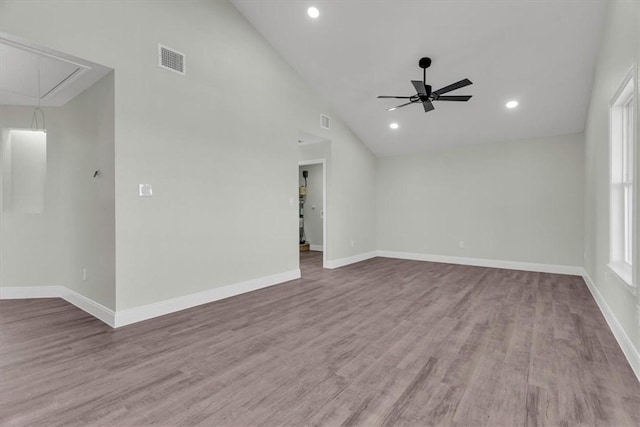 empty room with visible vents, wood finished floors, attic access, and baseboards