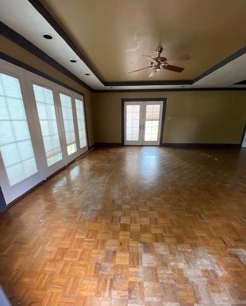 spare room with ceiling fan, crown molding, light parquet flooring, and french doors