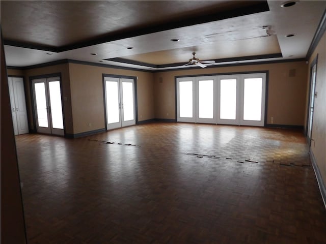 spare room featuring french doors, a wealth of natural light, ceiling fan, and a tray ceiling