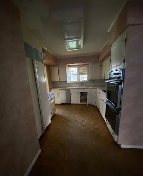 kitchen with dishwasher, black double oven, and white cabinets