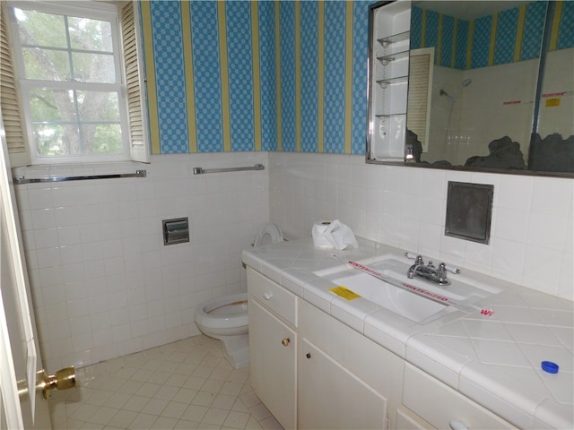 bathroom with tile walls, tile patterned flooring, vanity, and toilet