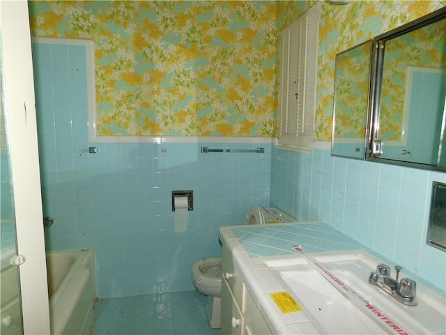 bathroom with tile walls, tile patterned floors, vanity, a tub, and toilet