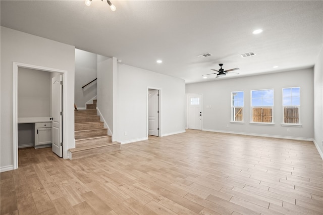 unfurnished living room with visible vents, a ceiling fan, recessed lighting, light wood finished floors, and stairs