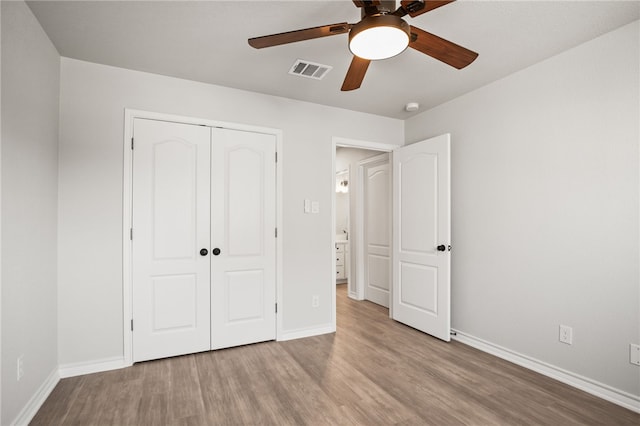 unfurnished bedroom with visible vents, baseboards, a closet, and wood finished floors