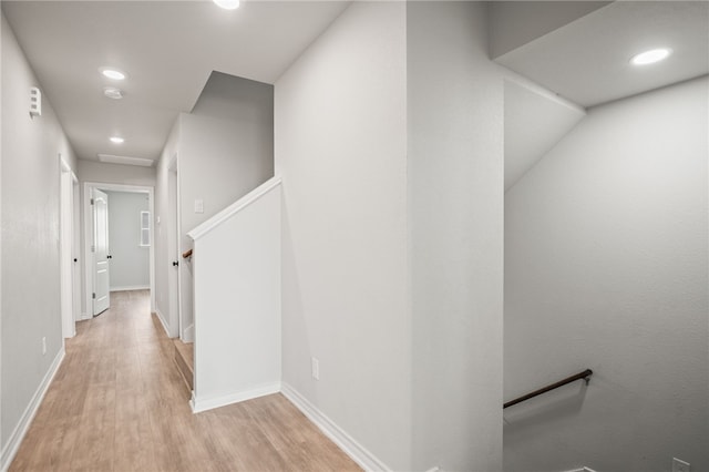 hall with recessed lighting, baseboards, an upstairs landing, and wood finished floors