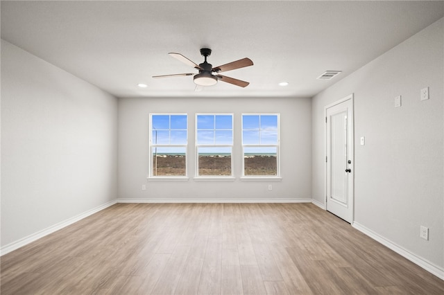 spare room with visible vents, wood finished floors, recessed lighting, baseboards, and ceiling fan