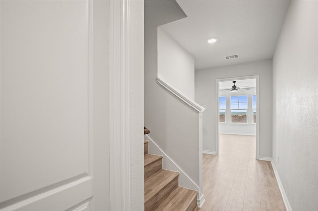 stairs with visible vents, baseboards, a ceiling fan, and wood finished floors