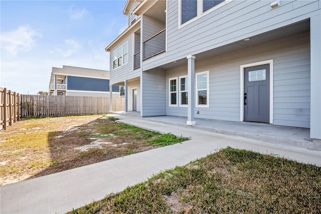 entrance to property featuring a patio and fence