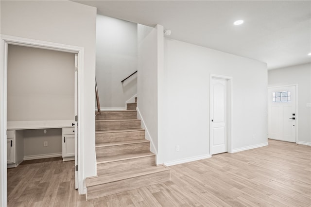 stairway featuring recessed lighting, baseboards, and wood finished floors