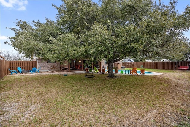 view of yard with a fenced in pool and a fire pit