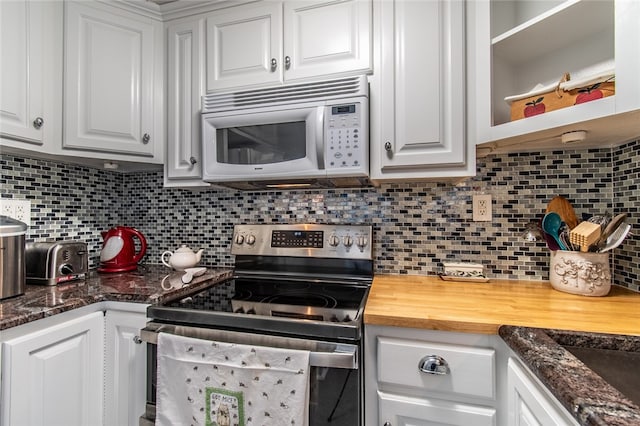 kitchen featuring butcher block countertops, electric stove, backsplash, and white cabinets