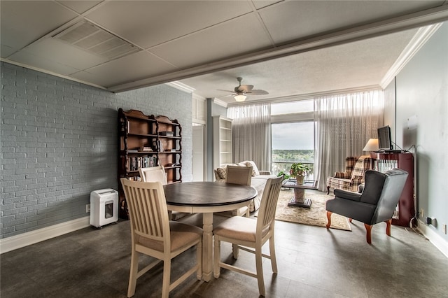 dining space with brick wall, ceiling fan, and crown molding