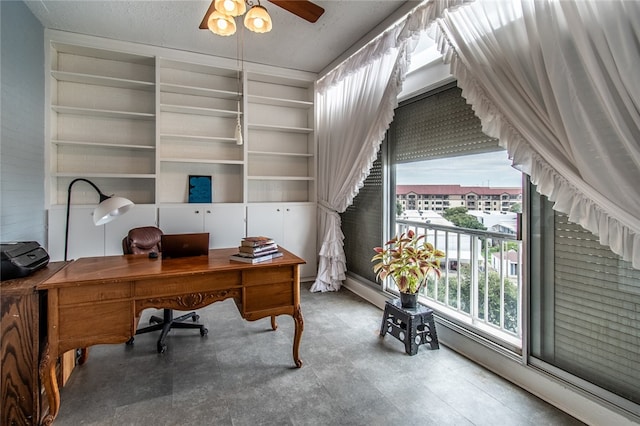 office space featuring a wealth of natural light, ceiling fan, and a textured ceiling