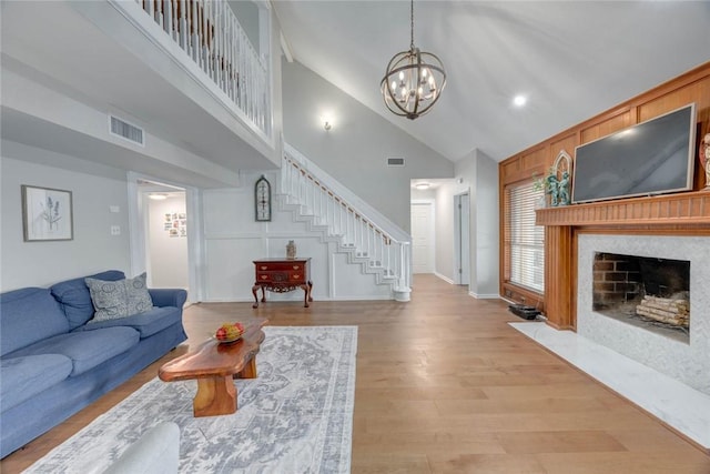 7506 Bistineau Dr, Corpus Christi, TX 78413 - living room with stairs, high vaulted ceiling, a chandelier, a fireplace with flush hearth, and light wood-style floors