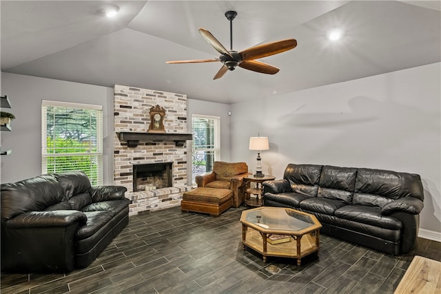 living room with a brick fireplace, lofted ceiling, dark wood-type flooring, and ceiling fan