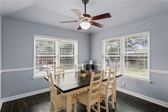 dining space with dark hardwood / wood-style flooring, vaulted ceiling, and ceiling fan