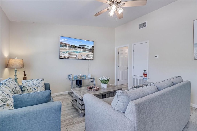 living area featuring baseboards, visible vents, a ceiling fan, lofted ceiling, and wood finish floors