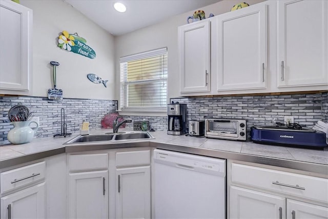 kitchen featuring light countertops, white cabinets, white dishwasher, and a sink