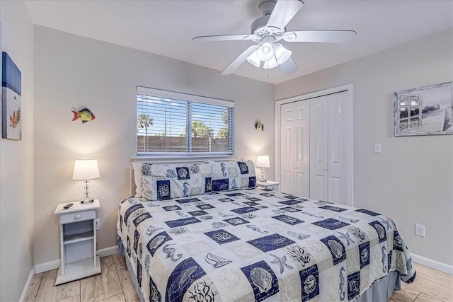 bedroom with light wood finished floors, a ceiling fan, baseboards, and a closet