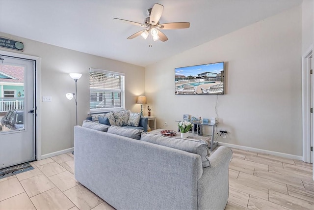 living room with a ceiling fan, wood tiled floor, vaulted ceiling, and baseboards