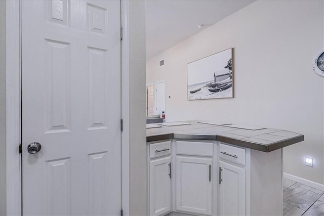 bar featuring marble finish floor and baseboards