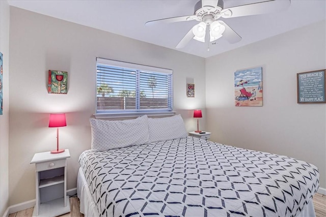 bedroom with a ceiling fan and baseboards