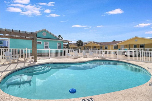 community pool with a patio, fence, and a pergola