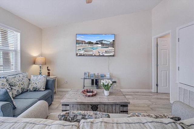 living room with lofted ceiling, wood finished floors, visible vents, and baseboards