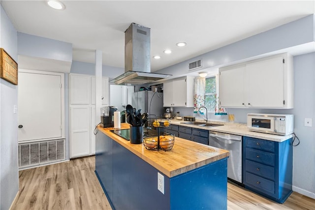 607 E 11th St, Bishop, TX 78343 - kitchen featuring island exhaust hood, stainless steel appliances, blue cabinets, a sink, and wooden counters