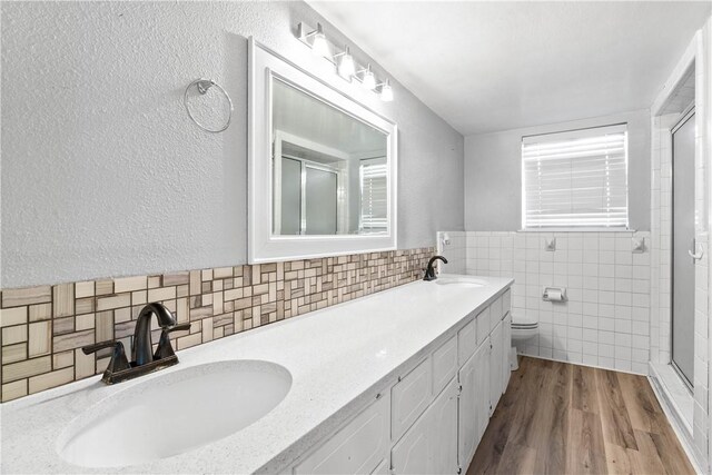 607 E 11th St, Bishop, TX 78343 - full bath with tile walls, a stall shower, double vanity, toilet, and wood finished floors
