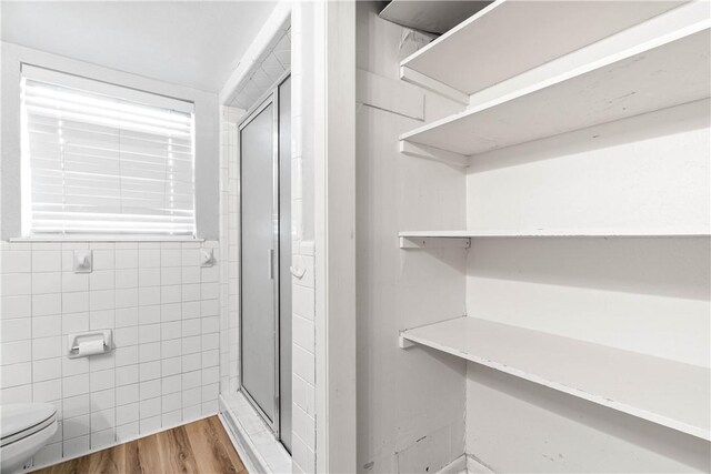 607 E 11th St, Bishop, TX 78343 - bathroom featuring a stall shower, toilet, and wood finished floors