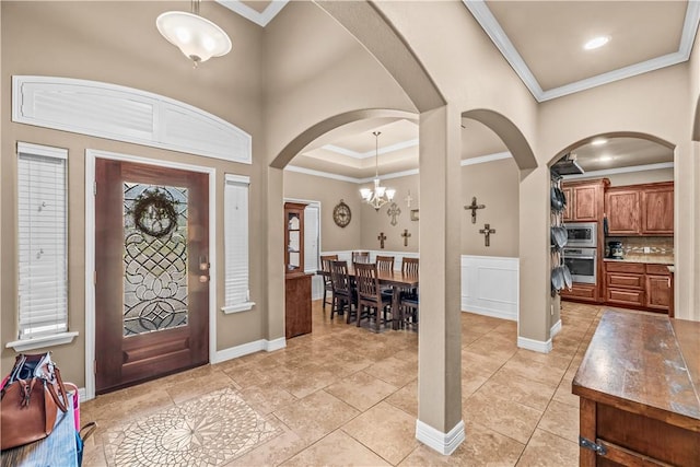 2004 Chesapeake Bay Dr, Portland, TX 78374 - entrance foyer with crown molding, arched walkways, a chandelier, baseboards, and light tile patterned floors