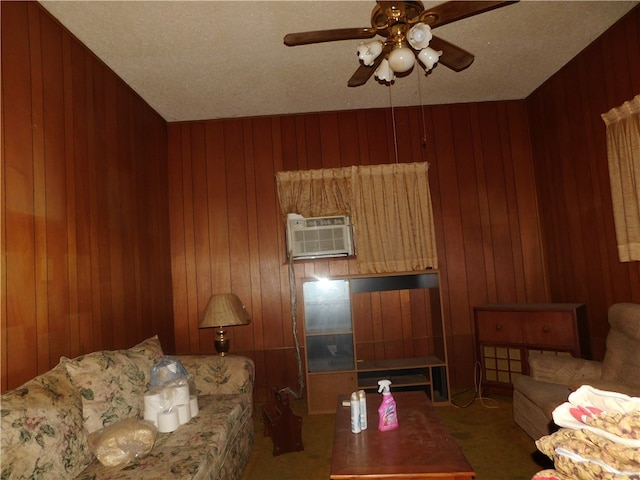 living room with a textured ceiling, carpet floors, wooden walls, and ceiling fan