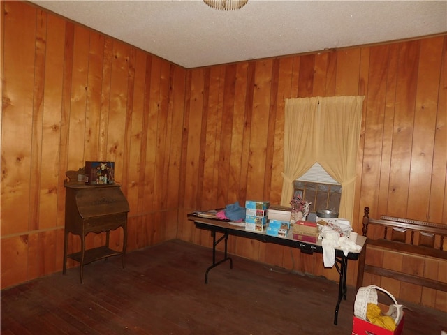 miscellaneous room with wooden walls, a textured ceiling, and dark hardwood / wood-style floors