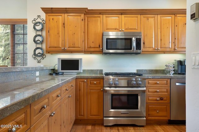111 Club Cottage Dr, Edwards, CO 81632 - kitchen with appliances with stainless steel finishes, brown cabinets, and light wood-style floors