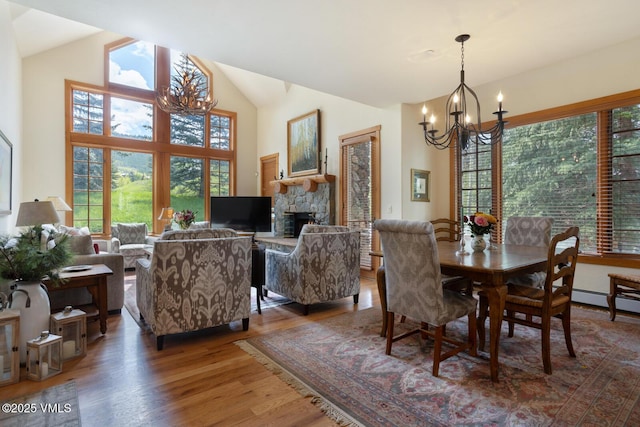 111 Club Cottage Dr, Edwards, CO 81632 - dining room with a chandelier, wood finished floors, vaulted ceiling, and a stone fireplace