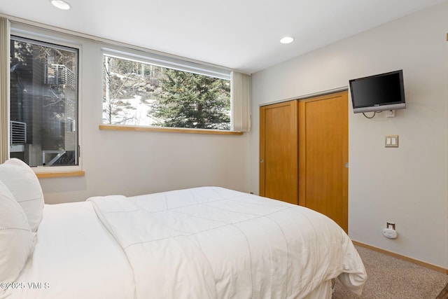 carpeted bedroom featuring baseboards, a closet, and recessed lighting