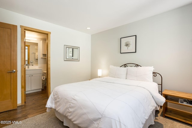 bedroom featuring ensuite bath, dark wood finished floors, and recessed lighting