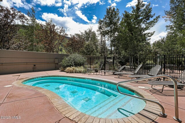 view of pool with a patio and fence