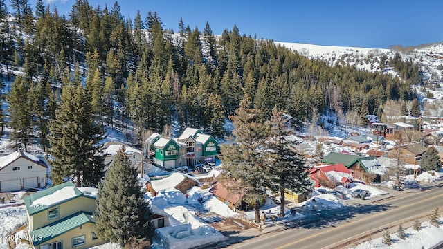 snowy aerial view with a residential view and a view of trees