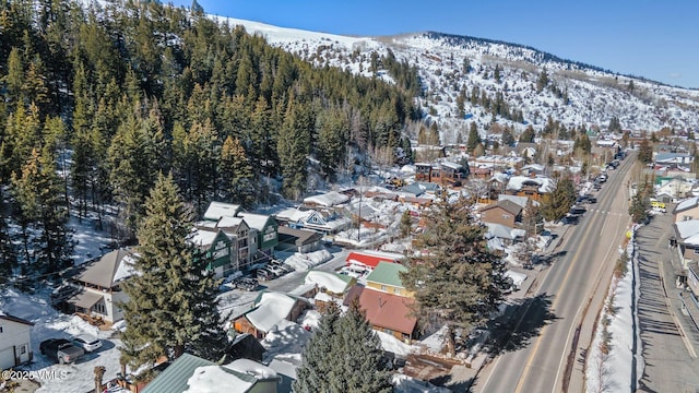 snowy aerial view with a residential view and a mountain view