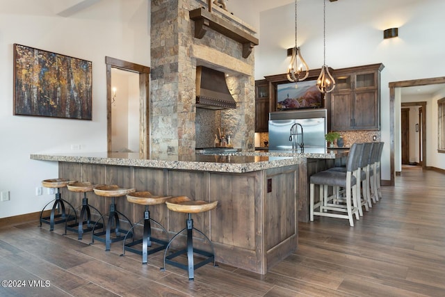1288 E Haystacker Dr, Eagle, CO 81631 - kitchen with built in fridge, pendant lighting, tasteful backsplash, a kitchen breakfast bar, and wall chimney range hood