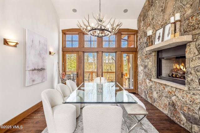 37 Aspen Meadows Rd, Edwards, CO 81632 - dining room with a chandelier, a fireplace, plenty of natural light, wood finished floors, and a high ceiling