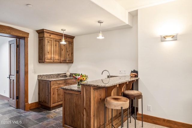 37 Aspen Meadows Rd, Edwards, CO 81632 - bar area featuring baseboards, decorative light fixtures, and dark stone finish floors