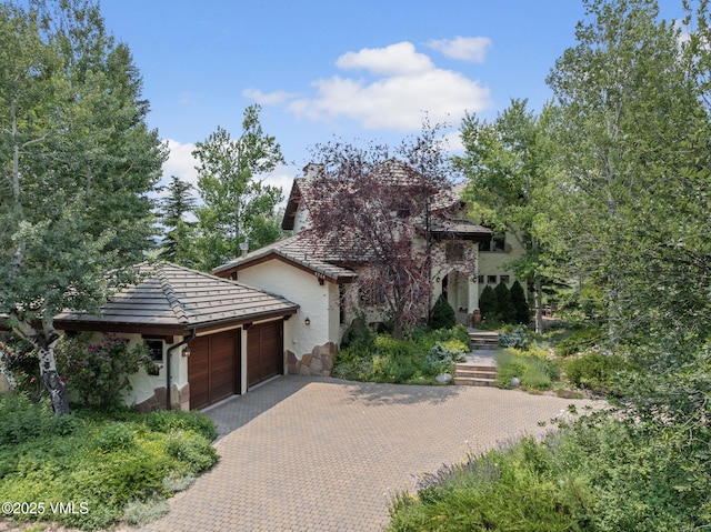 225 Alcazar Dr, Edwards, CO 81632 - view of front of house with a garage, decorative driveway, stone siding, and stucco siding