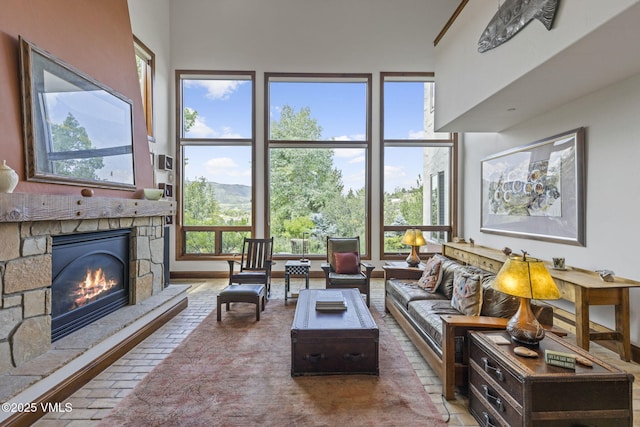 225 Alcazar Dr, Edwards, CO 81632 - living room featuring a stone fireplace, a mountain view, and a high ceiling