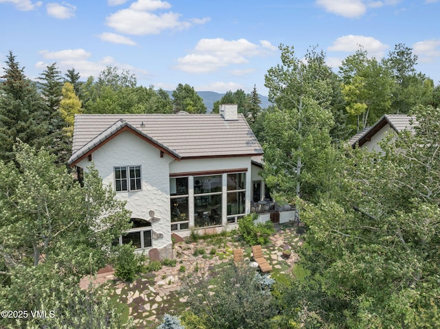 225 Alcazar Dr, Edwards, CO 81632 - rear view of house with stucco siding, a sunroom, and a chimney